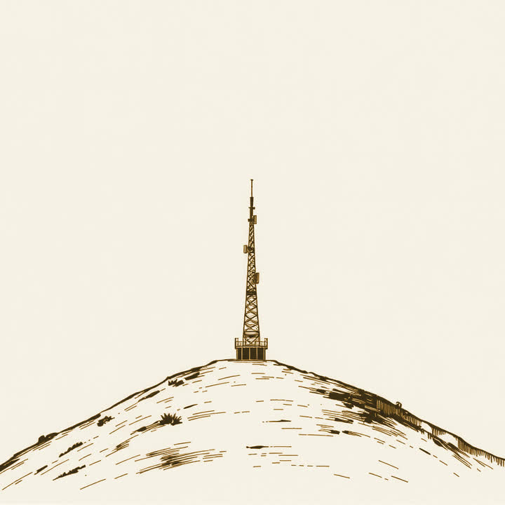 A tall wireless mast standing on a bare hilltop against an open sky, nothing else, no border