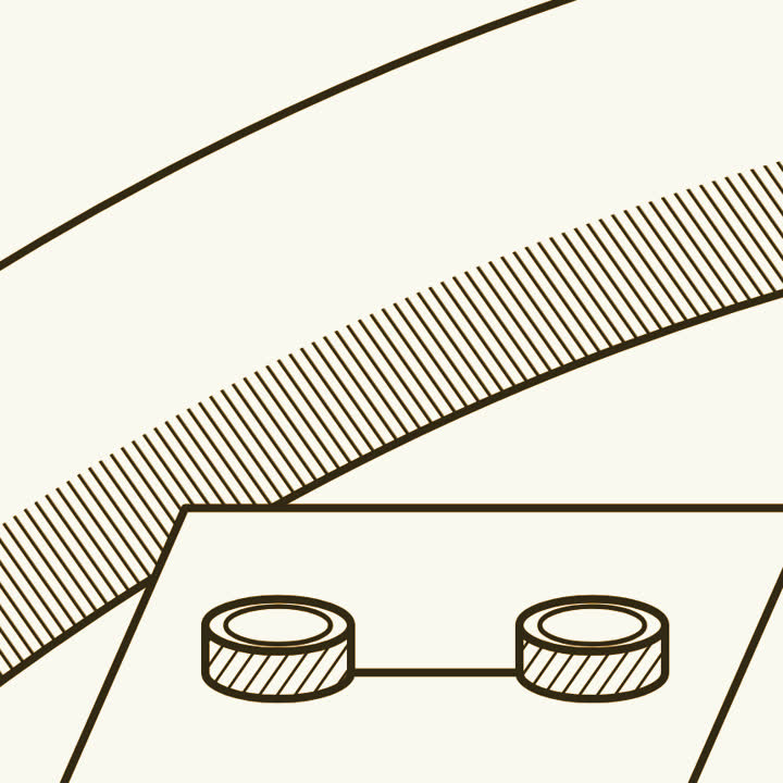 Two small round drums joined by a track on a chip, and behind them one smooth strand of hair several times wider than a drum
