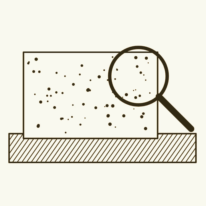 A glass photographic plate scattered with dots on a light box, with a magnifying glass over one corner