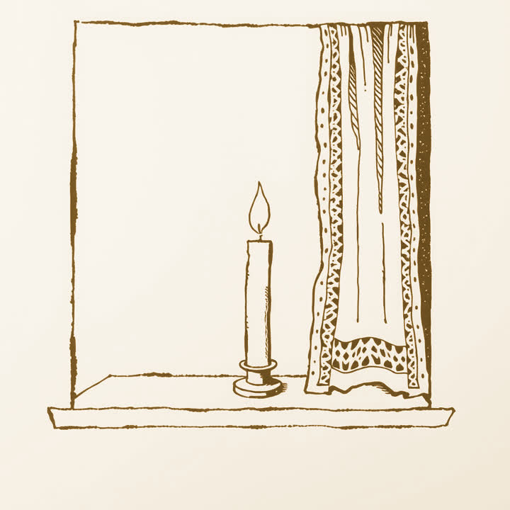 A lit candle standing on a windowsill beside a dry lace curtain
